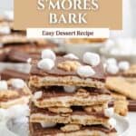 Chocolate s’mores bark stacked on a plate, topped with mini marshmallows, surrounded by graham crackers. Text: 4 Ingredient S’mores Bark.