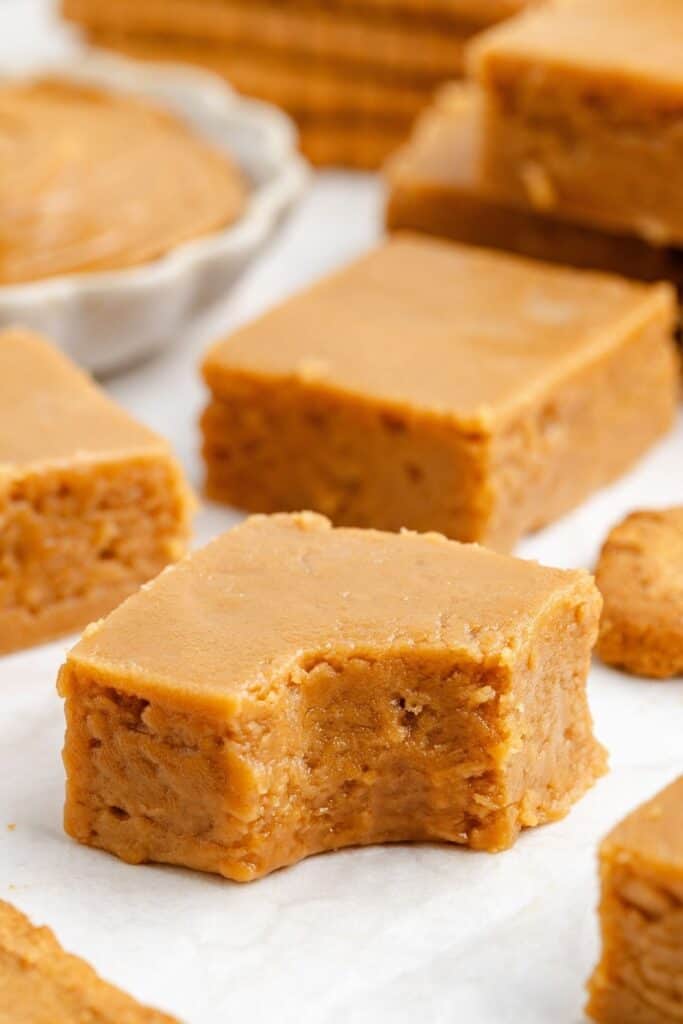 Several squares of 2 Ingredient cookie butter fudge, one with a bite taken out.