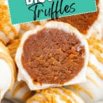 White chocolate-covered Biscoff truffles, one halved to reveal the brown spiced cookie filling.